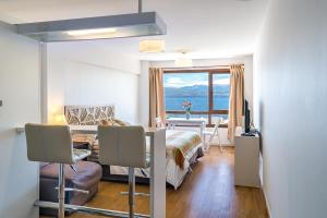 a bedroom with a bed and a desk and a table at Bariloche vista al lago, piscina, pleno centro in San Carlos de Bariloche