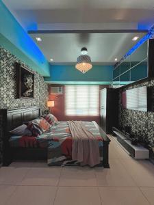 a bedroom with a bed in a room with blue lights at The Beacon Residences Condominium in Manila