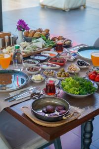 una mesa con muchos platos de comida. en Sandora Boutiuqe Hotel, en Yalıkavak