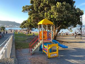 a playground in a park next to the beach at Beach front House in Wellington