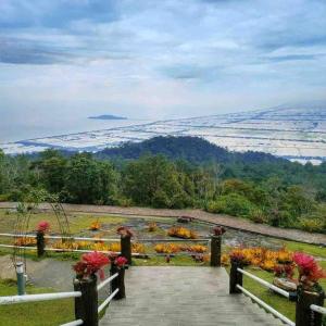 vistas a un jardín con flores en una valla en Habibie Homestay-Gunung Jerai en Guar Chempedak