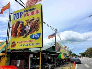 Una señal para un restaurante de rosquillas en una calle en Habibie Homestay-Gunung Jerai en Guar Chempedak