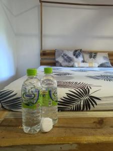 アルガムベイにあるStarfish Cabbanaのベッドの横のテーブルに座ったボトル入り飲料水2本
