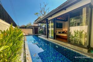 an image of a swimming pool in front of a house at Villa Canthy@Seminyak in Seminyak