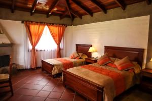 sypialnia z 2 łóżkami i oknem w obiekcie Hostería San Clemente w mieście Ibarra