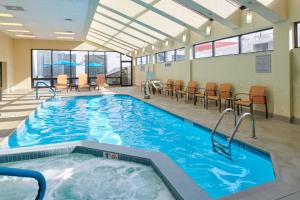 a large indoor pool with chairs and a table at Courtyard Columbus Downtown in Columbus