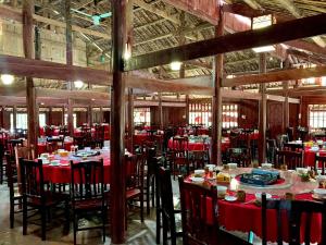 a dining room with red tables and chairs at Hồ Thang Hen in Trà Linh