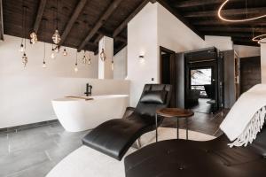 ein Badezimmer mit einer weißen Badewanne und einem Waschbecken in der Unterkunft ONKL XONNA Premium Alpin Chalets in Hüttschlag