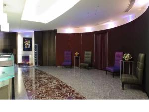 a waiting room with purple chairs and a fireplace at K Hotel - Yunghe in Yonghe