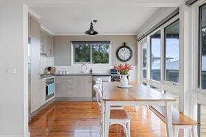 une cuisine avec une table et des chaises et une horloge au mur dans l'établissement Aloha Haven, à Ventnor 7 autres photos