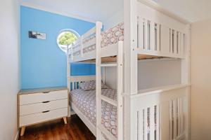 Cette chambre dispose de lits superposés, d'une échelle et d'un lit superposé dans une maison. dans l'établissement Aloha Haven, à Ventnor