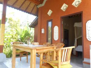 - une table et des chaises sur la terrasse couverte d'une maison dans l'établissement Cegeng Lestari Guesthouse, à Sidemen