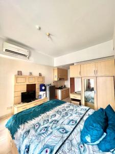 una camera con un grande letto e una cucina di Margonda Residence By Ensroom id a Kemirimuka Dua