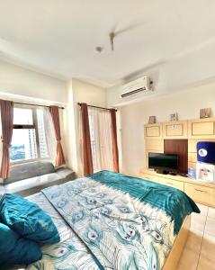 una camera con un grande letto e una televisione di Margonda Residence By Ensroom id a Kemirimuka Dua