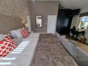 a large bed in a living room with a large couch at Plumwood Boutique Hotel by The Living Journey Collection in Franschhoek
