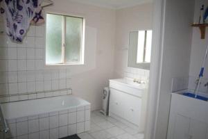 Un baño blanco con bañera y lavabo. en The Waters Edge at Tampa, en Cape Woolamai 7 fotos más