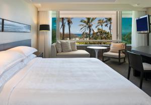 a bedroom with a large bed and a view of the ocean at Sheraton Grand Mirage Resort Gold Coast in Gold Coast