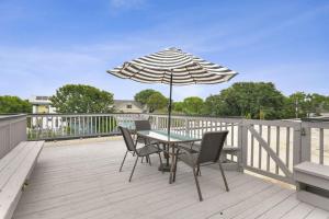 a table and chairs with an umbrella on a deck at The Sparkled Seahorse in Galveston