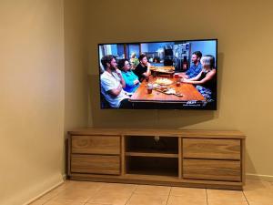 Elle comprend une télévision à écran plat installée sur un mur. dans l'établissement The Waves Oasis, à Cowes