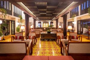 a lobby with chairs and tables in a building at Victoria Hoi An Beach Resort & Spa in Hoi An