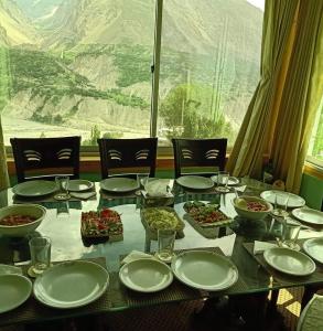 una mesa con platos y tazones de comida. en Hunza Lounge en Hunza