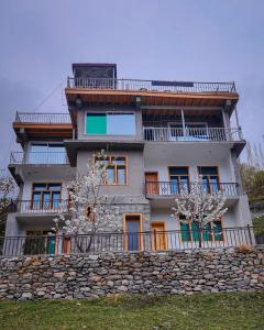 a building with a stone wall in front of it at Hunza Lounge in Hunza