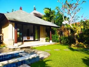 a house with a garden and a lawn with a house at 3BRBeautifull Villa Queen With Stunning Rice Field in Saba