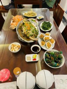 Khách Sạn Đại Dương FLC Sầm Sơn في سام سون: طاولة عليها العديد من أطباق الطعام