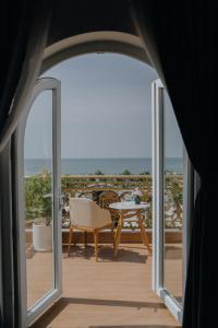 una puerta abierta a un balcón con mesa y sillas en Paris Hotel Bình Thuận en Tuy Phong