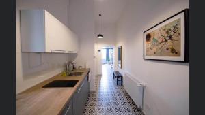 a kitchen with white cabinets and a tile floor at Ultracentral Apartment/Old Town in Timişoara