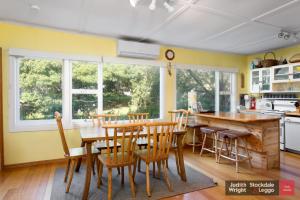 a kitchen with yellow walls and a wooden table and chairs at Heyley Haven in Ventnor