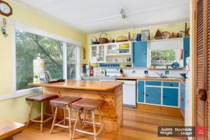 a kitchen with blue cabinets and a wooden counter top at Heyley Haven in Ventnor +4 photos