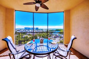 Un comedor con mesa y sillas y una gran ventana. en Vista Del Mar at Cape Harbour Marina, 10th Floor Luxury Condo, King Bed, Views!, en Cabo Coral