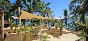 um pátio com uma tenda e cadeiras e uma piscina em Paradise Cove Resort em Port Vila