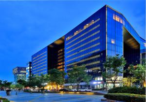 un grande edificio in vetro in una città di notte di SSAW Boutique Hotel Yingyang a Hangzhou