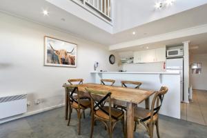 a kitchen and dining room with a wooden table and chairs at White Crystal 206 in Mount Hotham +1 photo