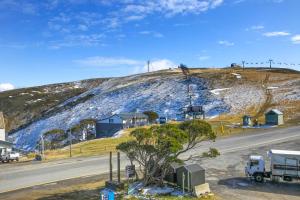 a hill with a house and a truck on a road at White Crystal 206 in Mount Hotham