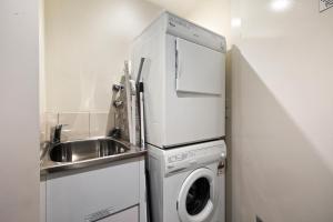 a kitchen with a washing machine and a sink at White Crystal 206 in Mount Hotham