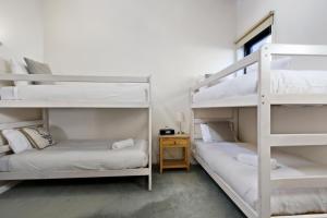 two bunk beds in a room with a desk at White Crystal 206 in Mount Hotham