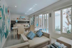 een woonkamer met een bank en een eetkamer bij The Wina Villa Canggu by The Wina Resorts in Canggu