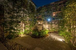 a building with ivy on the side of it at night at RESI STAY Jisco Hotel Kyoto Goshonishi in Kyoto