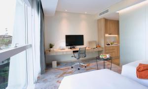 a bedroom with a desk with a monitor and a chair at Capri by Fraser Changi City, Singapore in Singapore