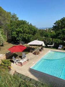 uma piscina com guarda-sóis e cadeiras e uma piscina em Chambres d'hôtes de charme La Joséline em Flayosc