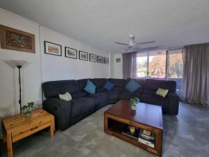 a living room with a couch and a coffee table at Tradewinds Apartments in Coffs Harbour