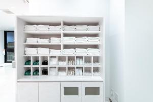 a white kitchen with white dishes on shelves at Hotel Sanrriott Osaka Hommachi in Osaka