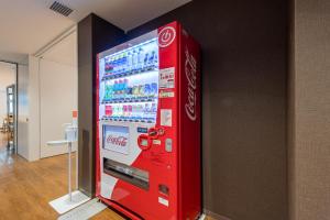a cocacola soda machine in a room at Hotel Sanrriott Osaka Hommachi in Osaka