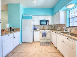 a kitchen with white appliances and a blue ceiling at NEW!! 2BR 4 Beds Condo with Pool in Galveston