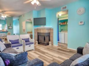 a living room with two couches and a fireplace at NEW!! 2BR 4 Beds Condo with Pool in Galveston