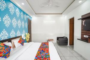 a bedroom with a bed and a blue wall at FabHotel Tanvi Premium in Gurgaon