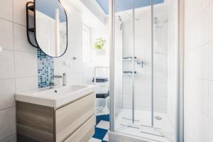 a bathroom with a sink and a shower at Ferienwohnung "UtTied" - komfortabel und modern! in Klausdorf Mecklenburg Vorpommern